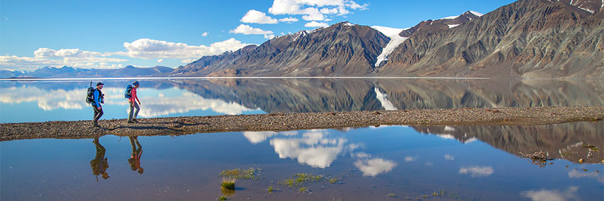 Hikers with clear water and mountains in the background