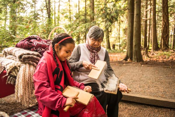 Une fillette d’une Première Nation locale et sa grand mère font une démonstration de l’art traditionnel du tricot au camping McDonald.