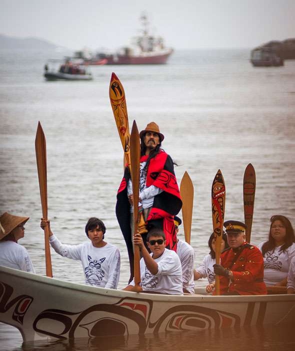 Un canot haïda arrive à Hlk’yah GawGa (baie Windy Bay), à Gwaii Haanas, pour l’inauguration du mât héraldique le 15 août 2013