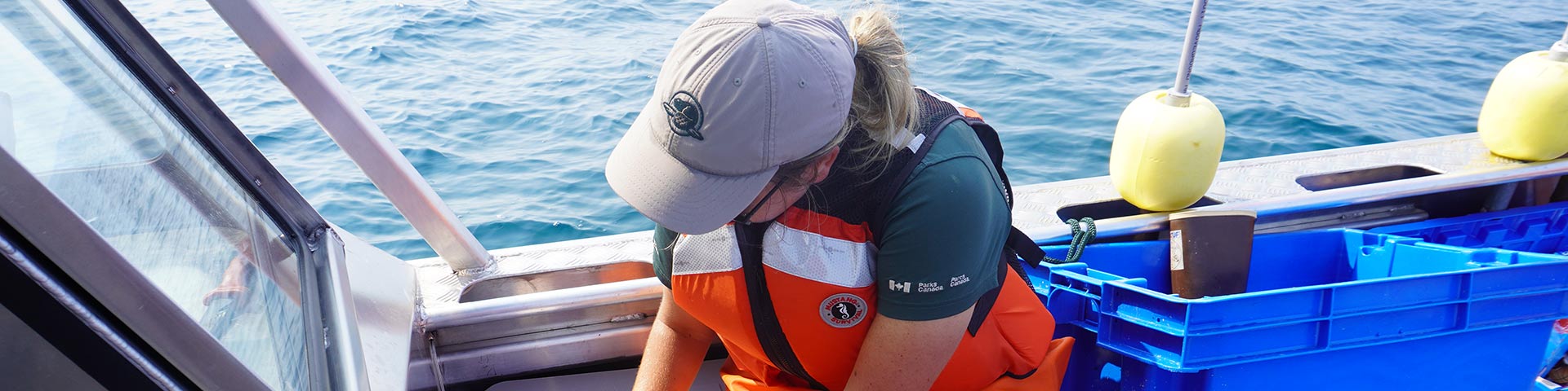 Le personnel de Parcs Canada échantillonne l’eau sur un bateau.