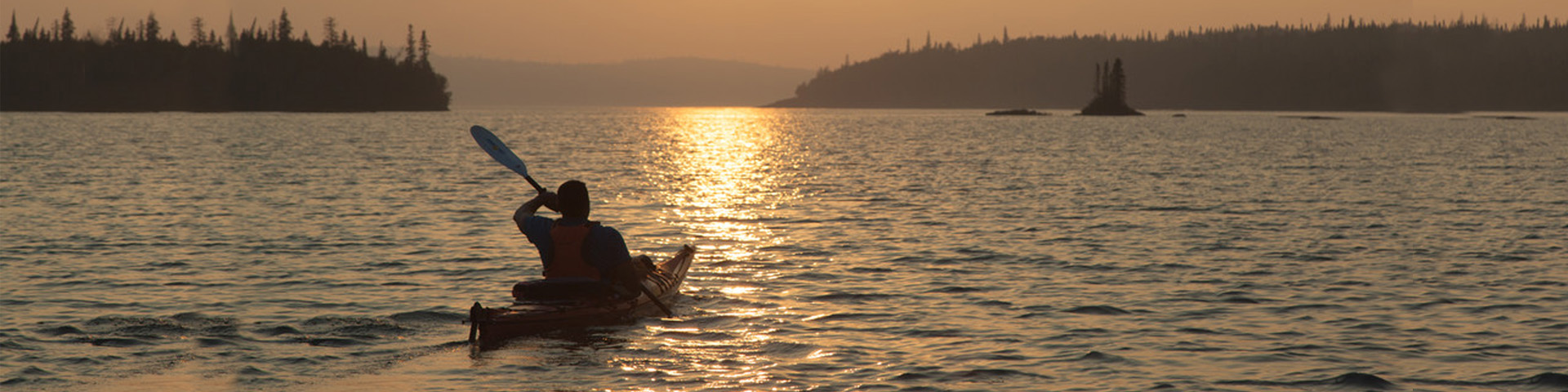 A person on a kayak during sunset on Lake Superior. 