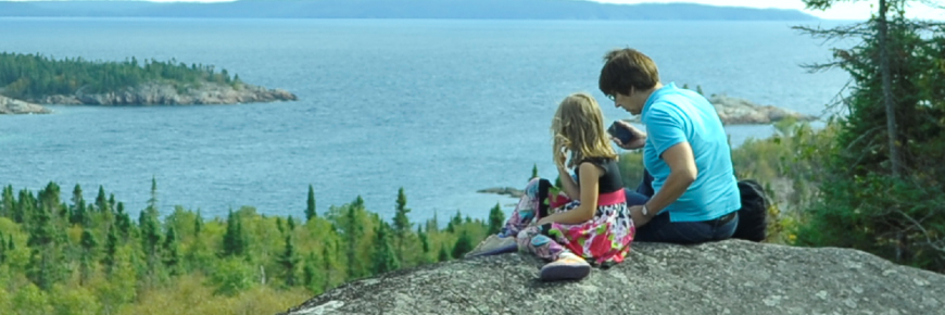 Two people at a viewpoint overlooking Lake Superior.