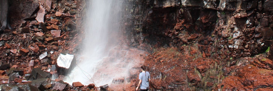 A person at the bottom of a waterfall.