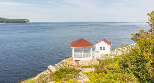 Deux cabanes blanches avec le toit rouge. L'une est un observatoire pour voir les baleines qui naviguent dans le Saint-Laurent. 
