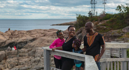 Une famille souriante est en plein air durant une journée d'été. 