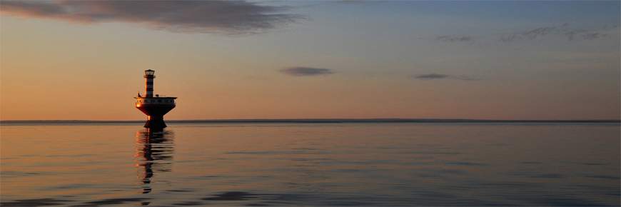 Vue du phare du Haut-fond Prince sur une mer calme.