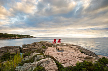 2 chaises rouges de Parcs Canada sur les rochers au Centre de découverte du milieu marin. 