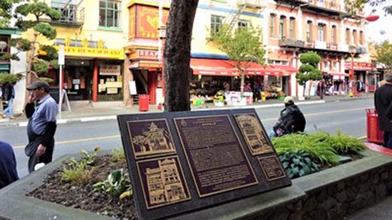 Une plaque commémorative installée sur un trottoir.