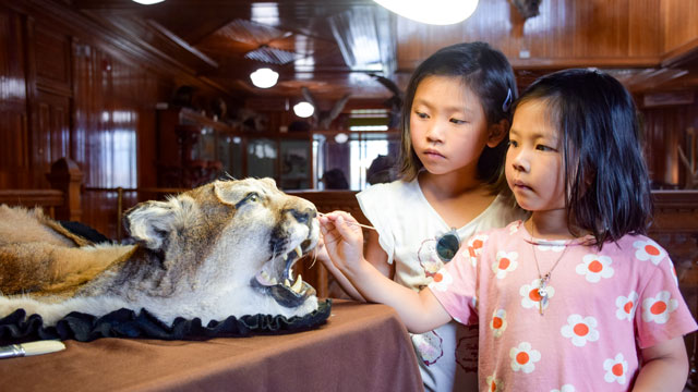 A Parks Canada heritage presenter assists children with art & crafts.
