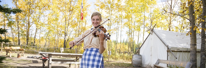 woman playing a fiddle outdoors