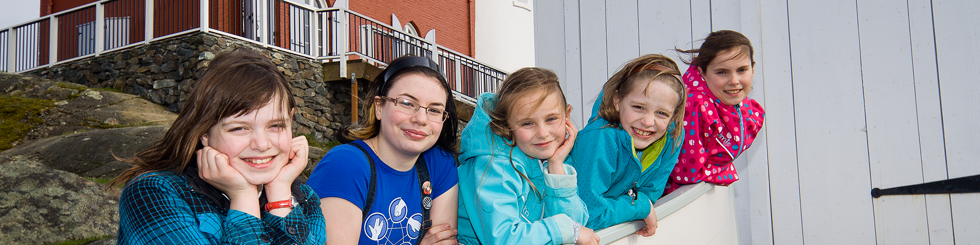 Cinq élèves d’âge scolaire se trouvent dans une barque sur la terre ferme.