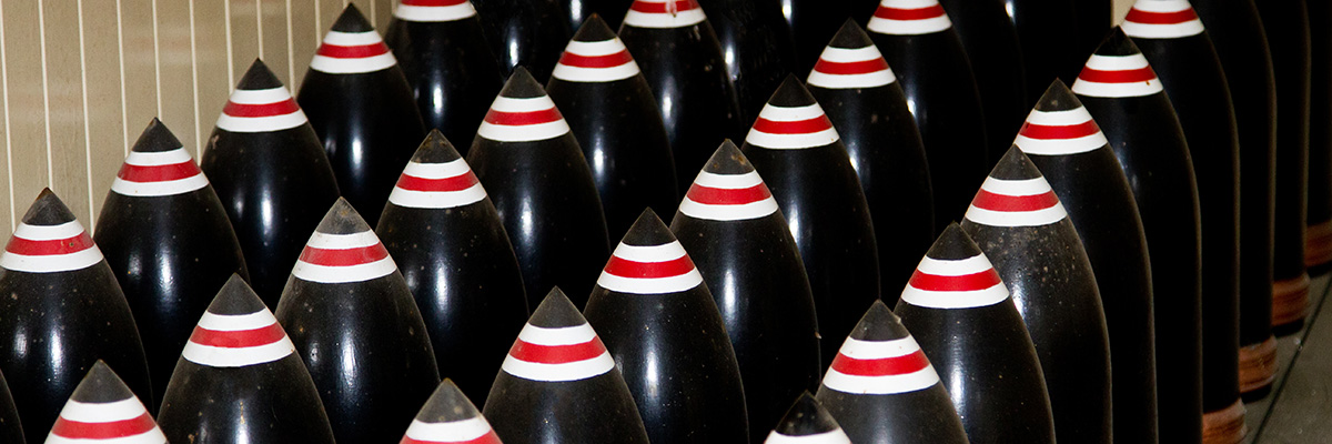 Close-up of artillery shell tips painted with black, white, and red stripes.