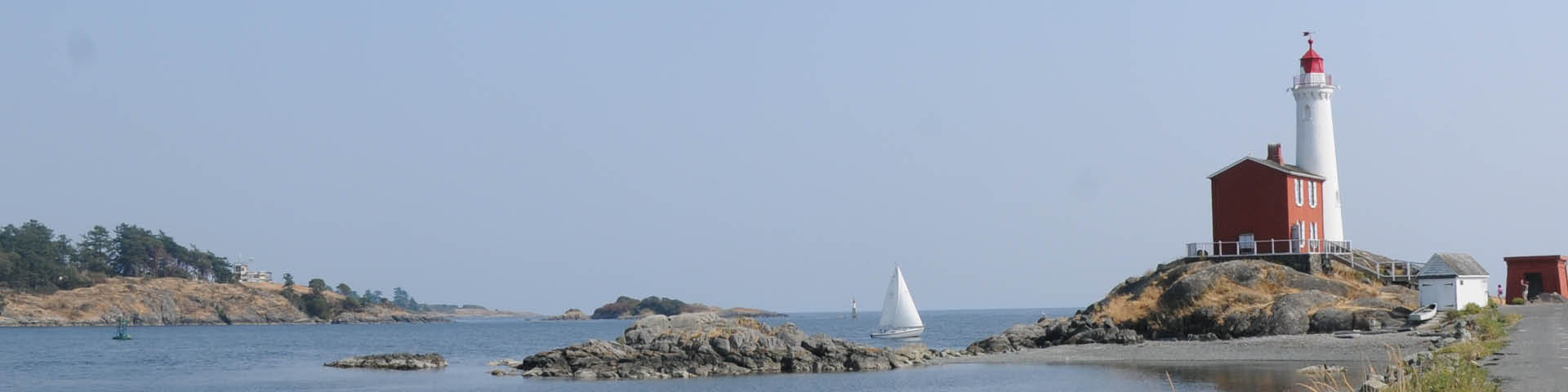 A lighthouse and a sailboat.