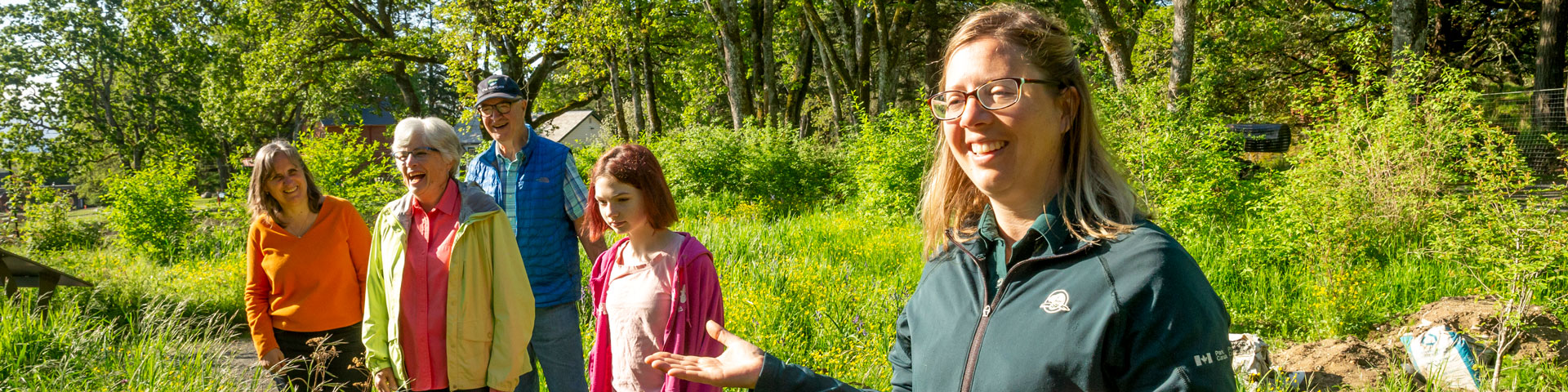 a group of people in nature with a Parks Canada interpreter in uniform