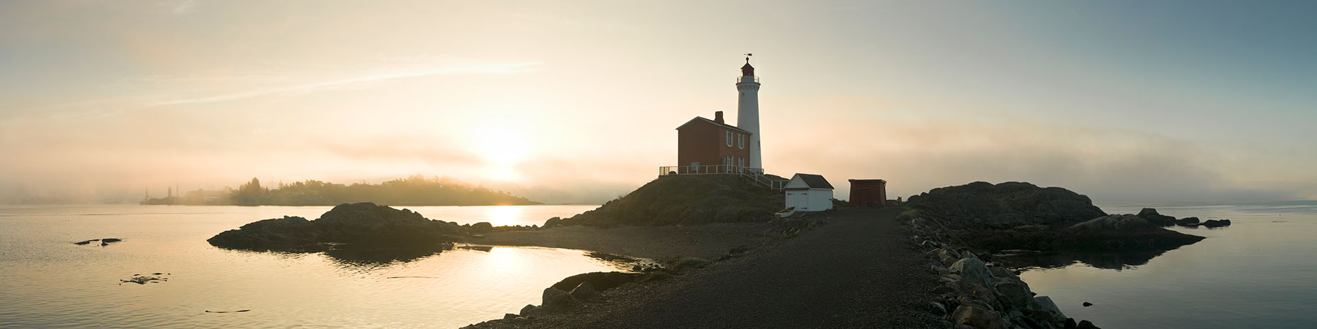 Sunrise and morning mist brings golden colours to Fisgard Lighthouse