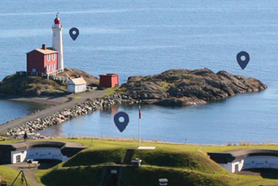 An area photo of Fort Rodd Hill’s lower battery and Fisgard lighthouse in the distance.
