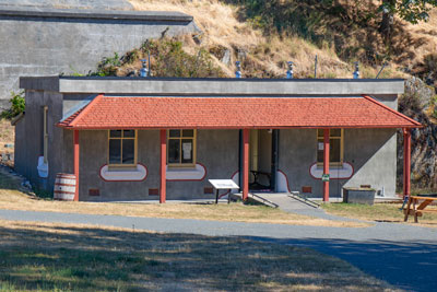 Photo of the Casemates, a concrete building with a red roof, covered porch.