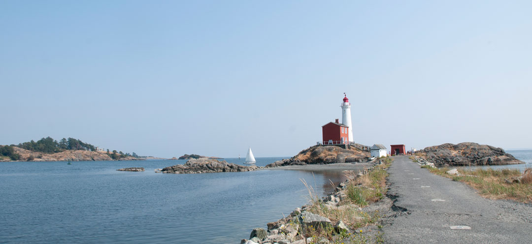 View of the Causeway leading to the lighthouse in the far distance, with a sailboat to its left