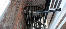 Photo of the black spiral staircase that leads to the second floor of the lighthouse.
