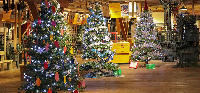 Three ornately decorated Christmas trees inside the cannery. 