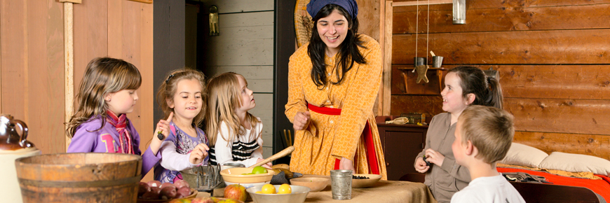 Children listen to school program with costumed interpreter at Fort Langley