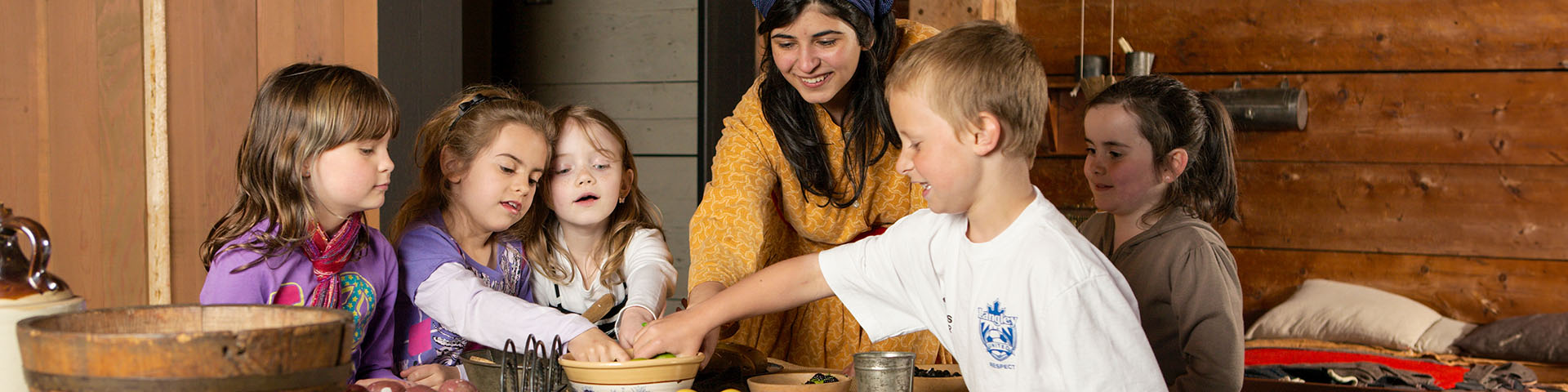 Children listen to school program with costumed interpreter at Fort Langley