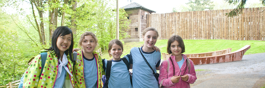 A group of girl guides pose in front of Fort Langley walls