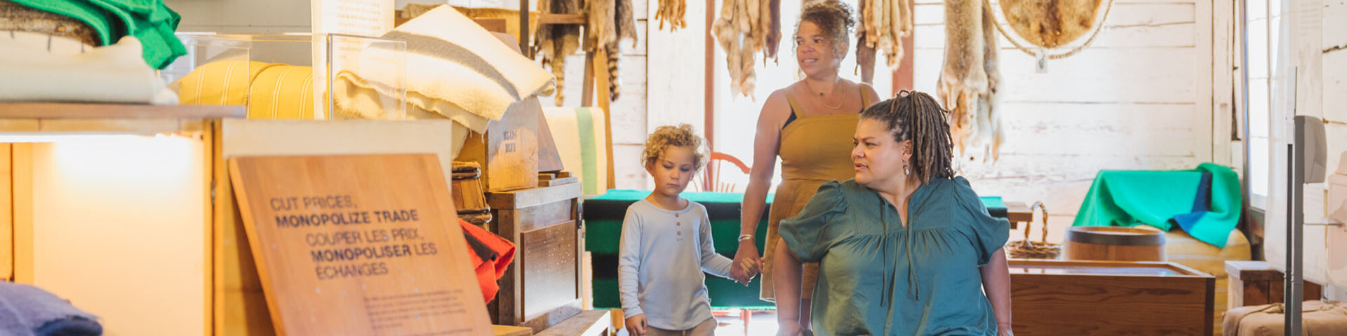 Deux parents, dont l’un en fauteuil roulant, et leur enfant, explorent une exposition à l’intérieur de l’entrepôt