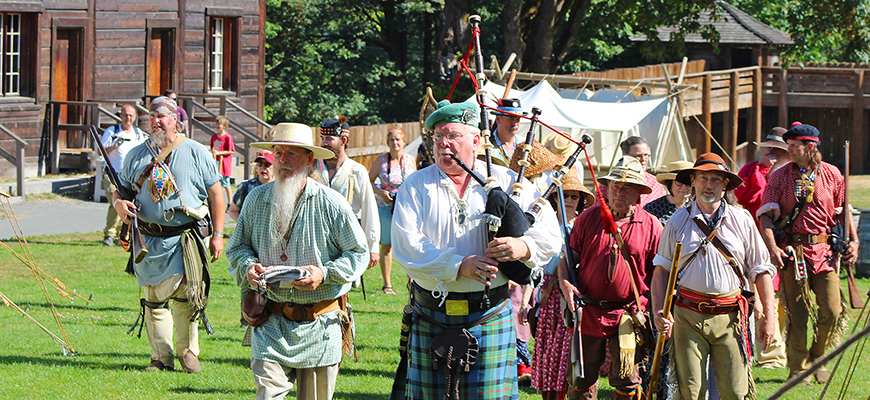 Fort Langley reenactors follow a bagpiper in a procession