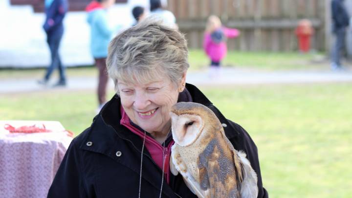 A person holding an owl.