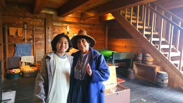 A costumed Indigenous elder and a young boy. 