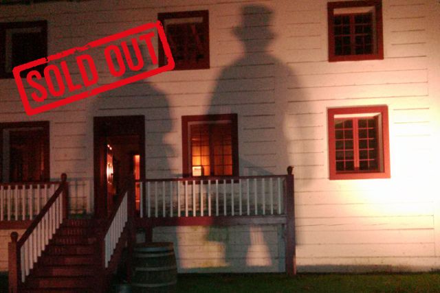 The Big house at night with two shadows cast on the front of the building.