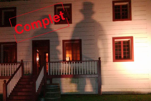 La Grande Maison de nuit avec deux ombres projetées sur la façade du bâtiment. 