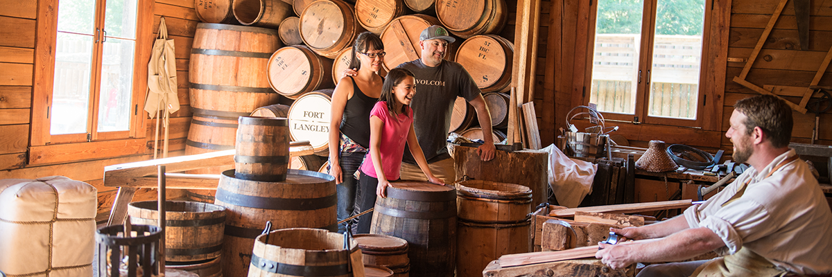 A family watches a barrel making demonstration in the cooperage