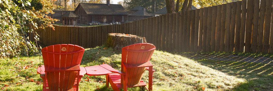 Les chaises rouges du Parcs Canada dehors la palissade du fort Langley