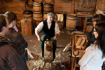 Un tonnelier en costume d’époque fait une démonstration du processus traditionnel de fabrication des tonneaux.