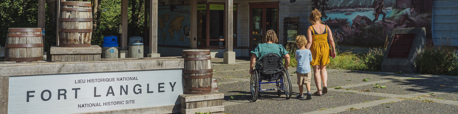 Quelques personnes se dirigent vers le Centre d’accueil depuis le stationnement. L’une d’elles utilise un fauteuil roulant manuel.