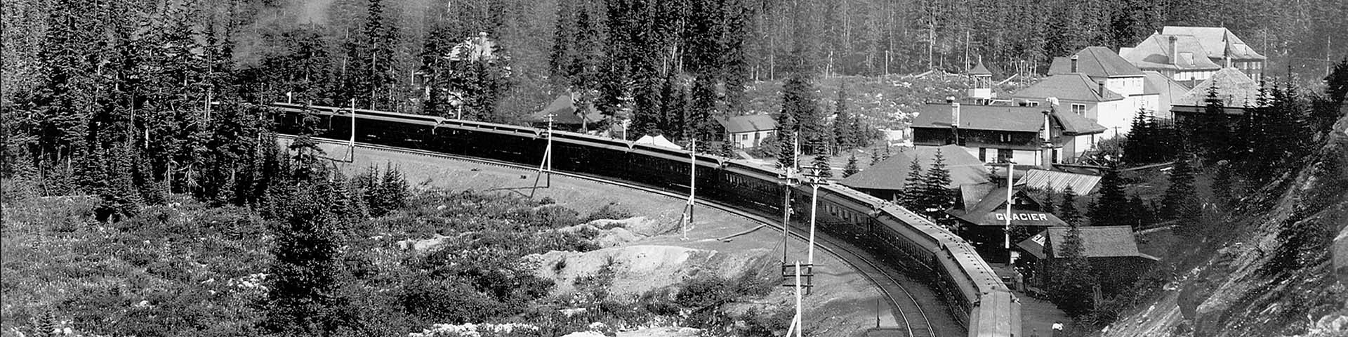 Black and white photo of a train passing through the old glacier house