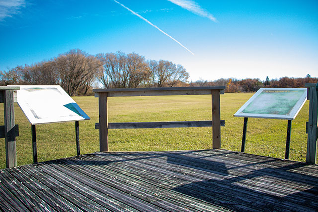 A wooden platform with two interpretive panels.