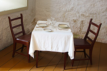 Two bentwood chairs at a table in the Motor Country Club display area of the Big House at Lower Fort Garry.