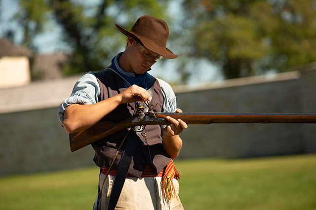 Un homme se prépare à tirer un coup de feu avec un fusil historique. 