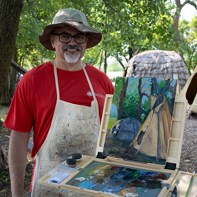Un homme se tient à côté d’une peinture à Lower Fort Garry.