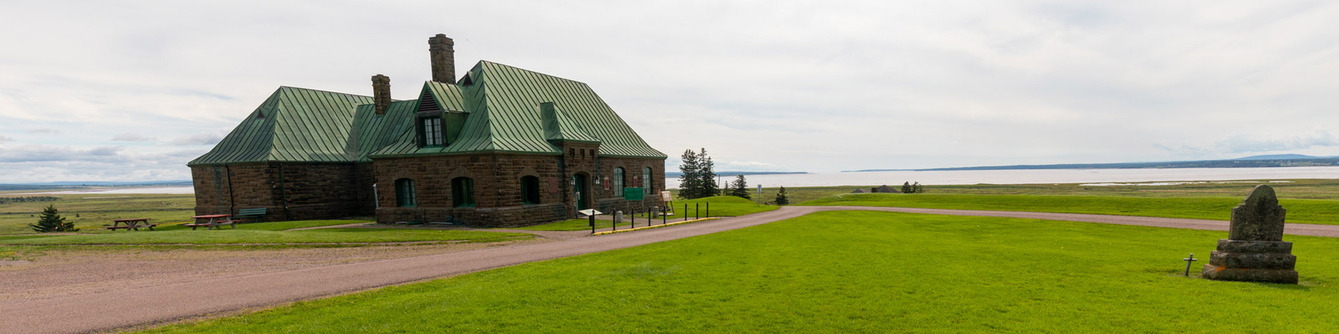 Outdoor view of Fort Beausejour - Fort Cumberland's visitor reception centre and museum, in a vast open area.