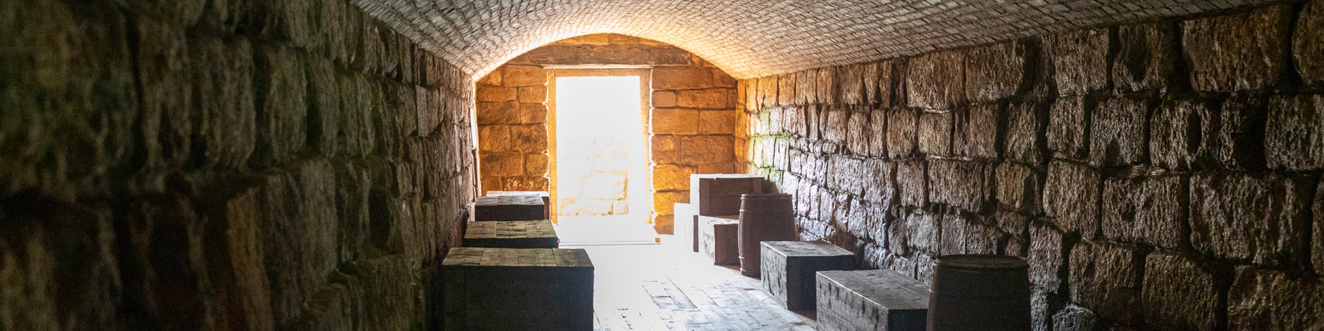 L'intérieur d'un tunnel, avec un sol en bois, des murs en briques et un plafond incurvé.