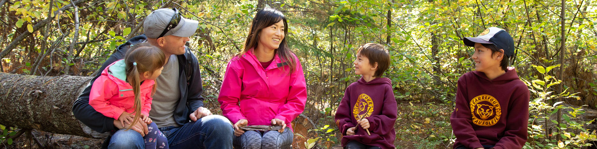 A family sitting on a tree trunk on the island.