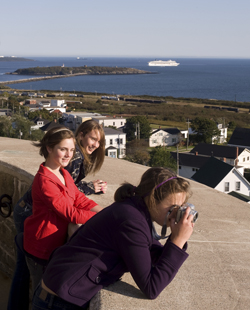 Three young girls taking pictures from the top of the tower