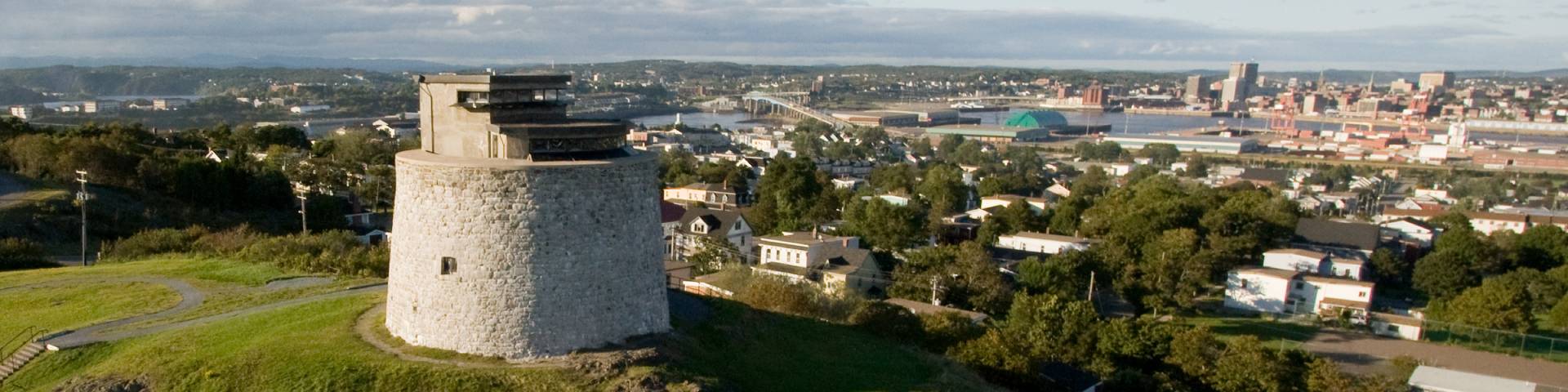 a white tower on a hill that overlooks a city