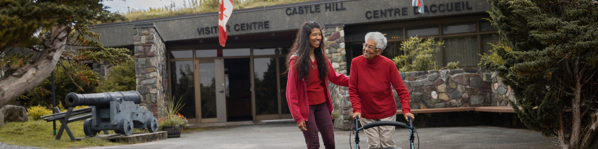 two people, one with a mobility device, walking away from the visitor centre