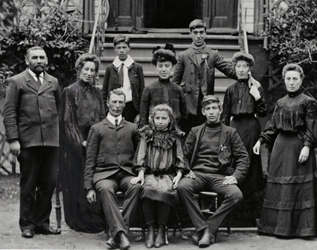 black and white photo of family in front of a house