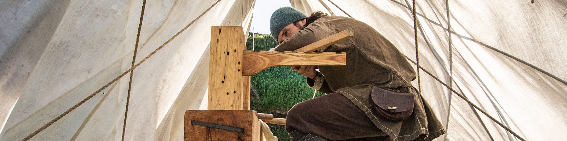 Un animateur-guide de Parcs Canada en costume viking construit avec du bois au lieu historique national de L'Anse aux Meadows